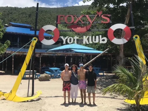 a group of people standing on top of a sandy beach