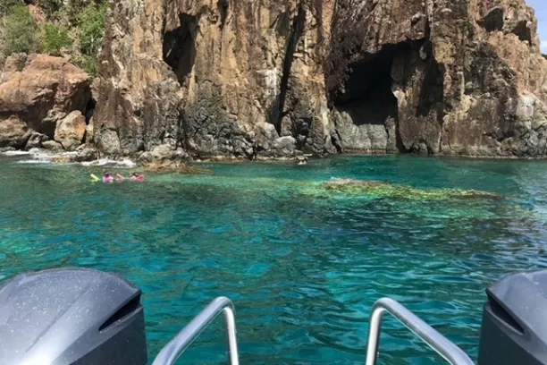 a chair sitting in front of a large rock next to water