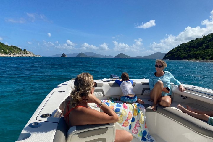 a woman sitting on a beach near a body of water