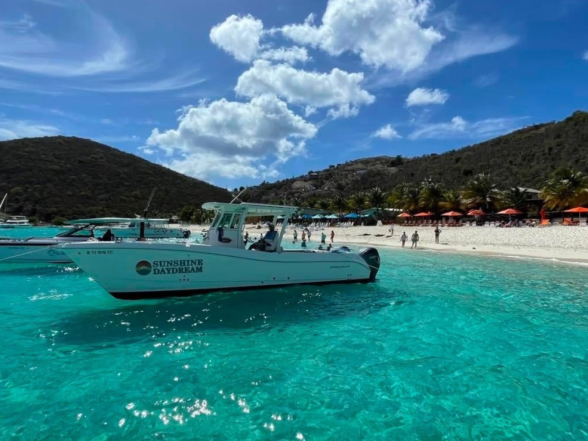 a blue and white boat sitting next to a body of water