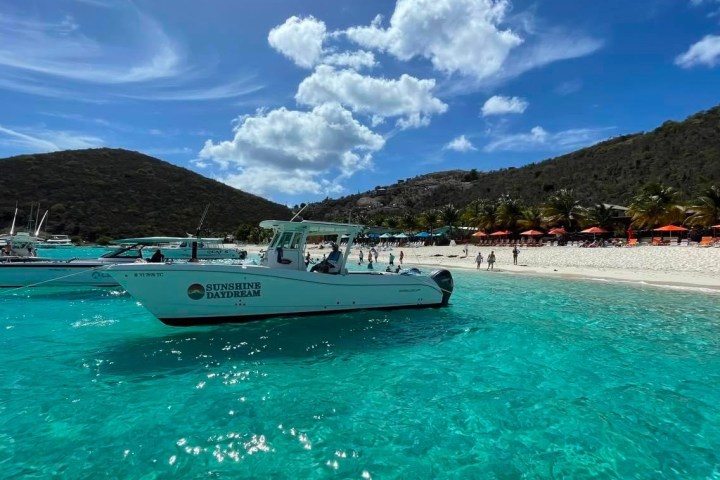 a blue and white boat sitting next to a body of water