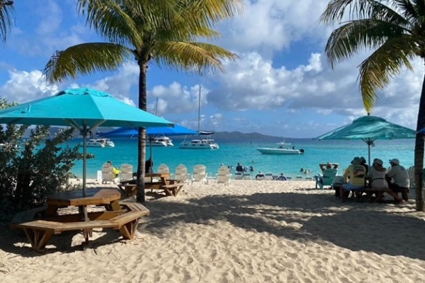 a group of lawn chairs sitting on top of a sandy beach
