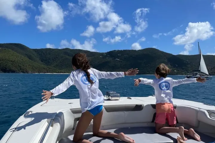 a woman sitting next to a body of water